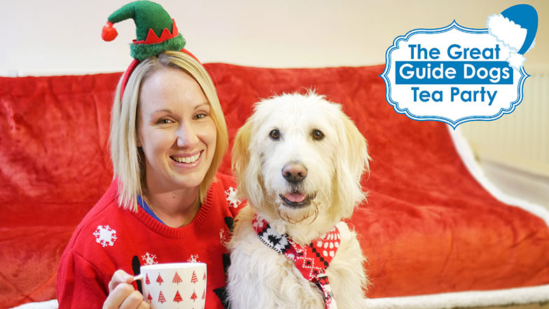 Woman wearing elf hat cuddling guide dog